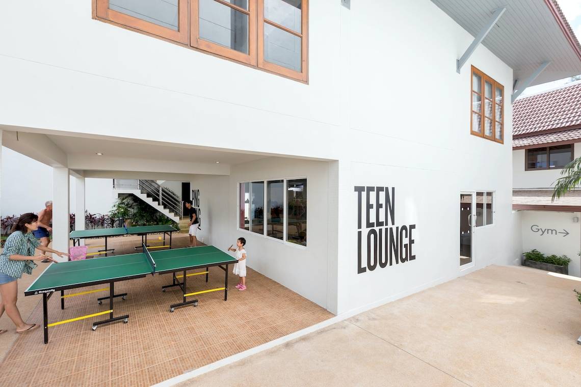 Familie spielt Tischtennis in der Teen Lounge des Sunwing Bangtao Beach Hotels.