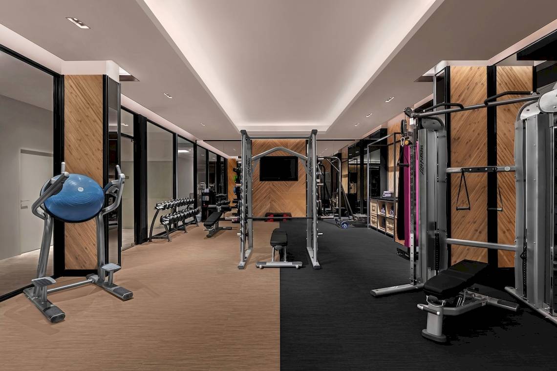 Fitnesscenter im Four Points by Sheraton Phuket Patong Beach Resort mit Geräten und Spiegeln.