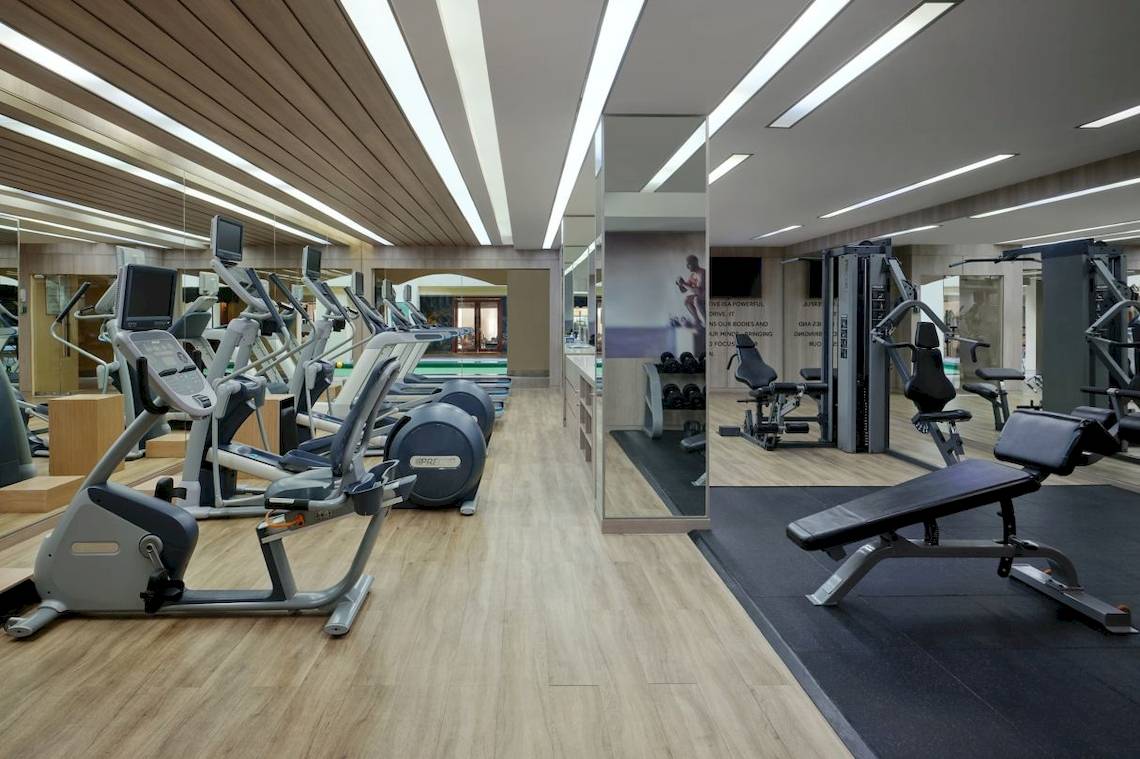 Fitnessstudio im Phuket Marriott Resort & Spa mit modernen Geräten und hellem Holzboden.