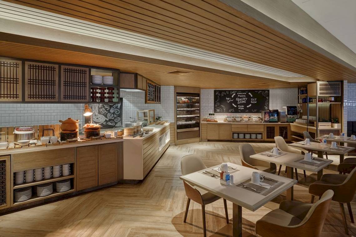 Frühstücksbereich im Phuket Marriott Resort & Spa Merlin Beach mit Buffet, Tischen und Stühlen.