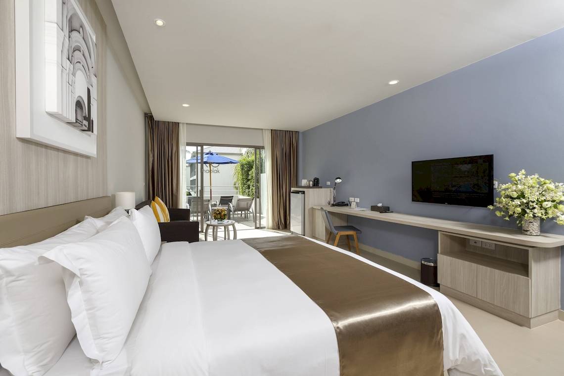 Innenansicht eines Hotelzimmers im X10 Khaolak Resort mit Bett, Fernseher und Schreibtisch.
