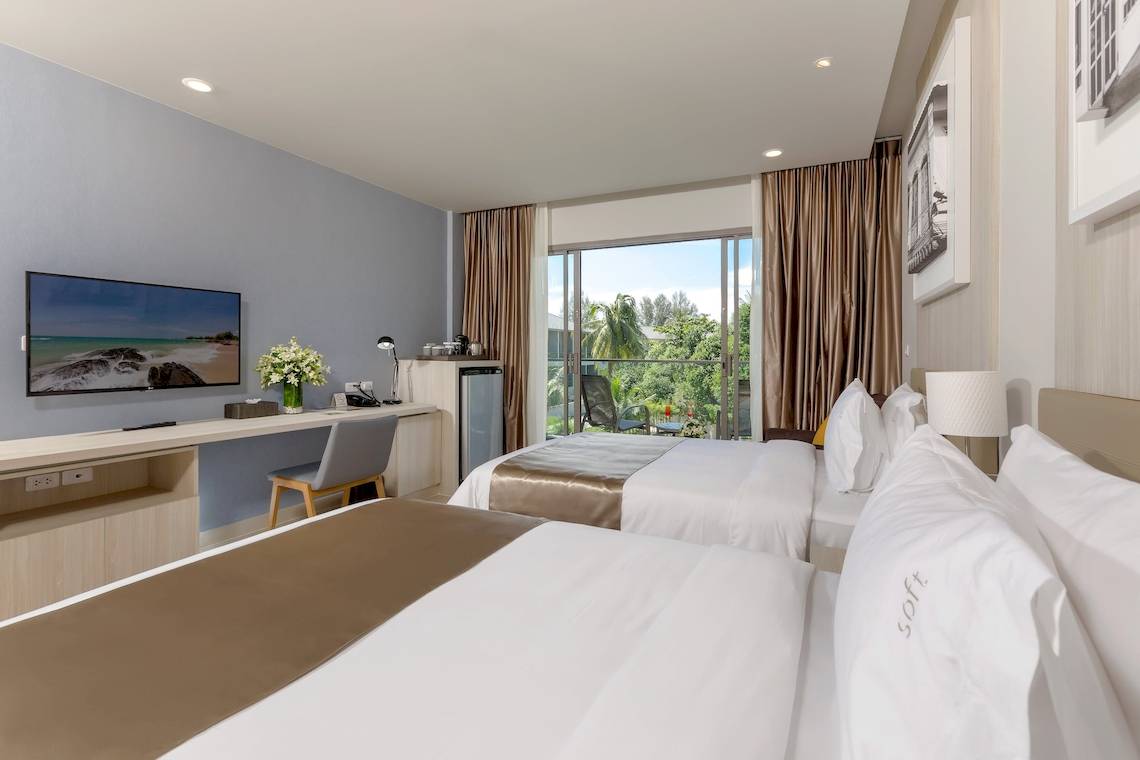 Zwei Betten mit Blick auf den Garten im X10 Khaolak Resort Hotelzimmer.