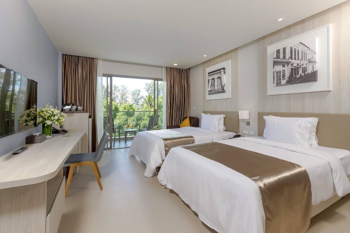 Doppelzimmer im X10 Khaolak Resort mit zwei Betten, Balkon und Fernseher.