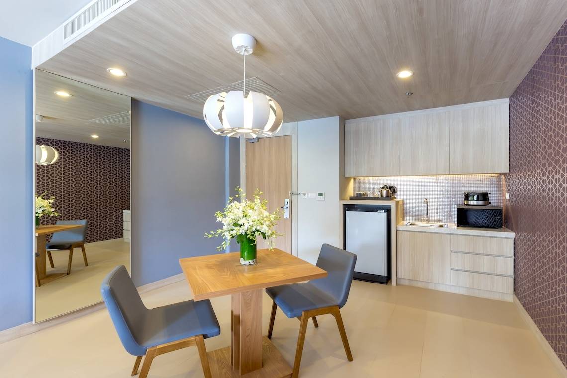 Innenansicht der Suite im X10 Khaolak Resort mit Tisch, Stühlen und Küchenbereich.