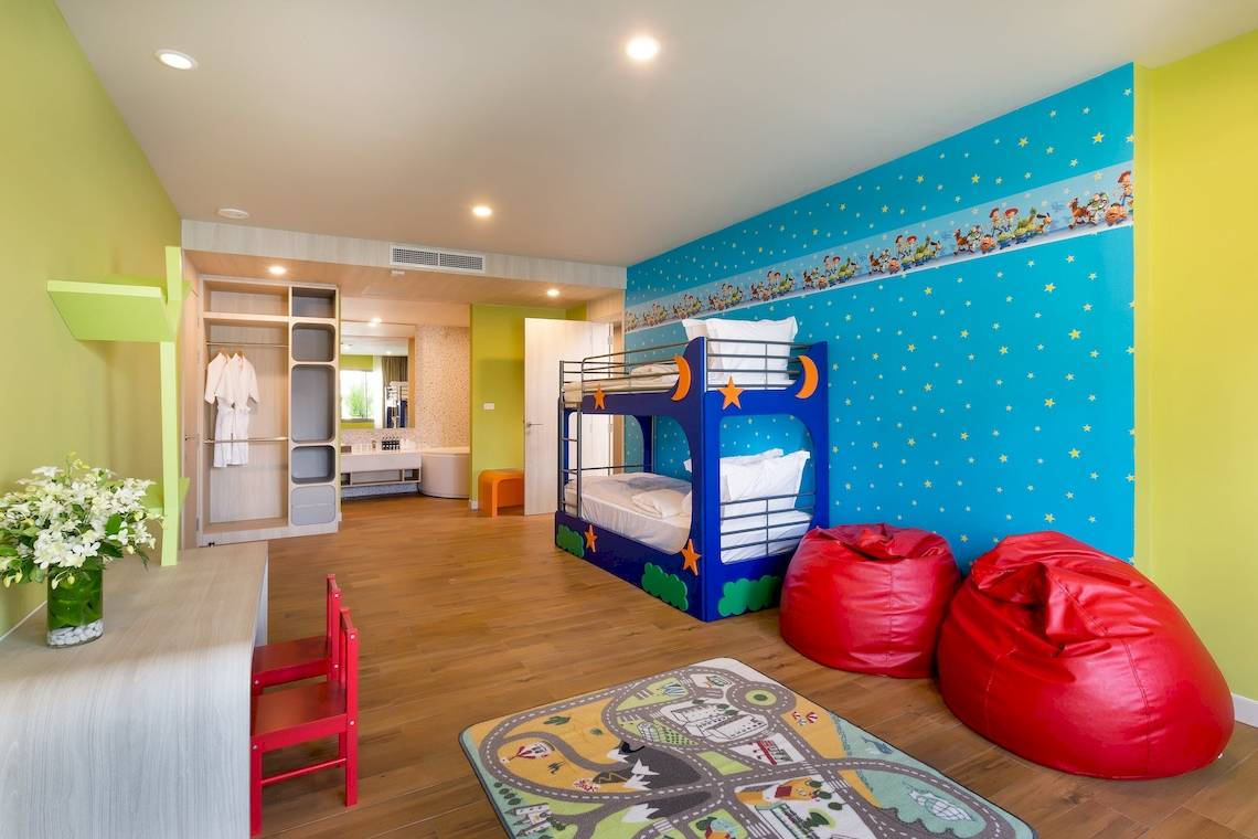 Kinderzimmer im X10 Khaolak Resort mit blauem Wandbild, zwei Etagenbetten und roten Sitzsäcken.