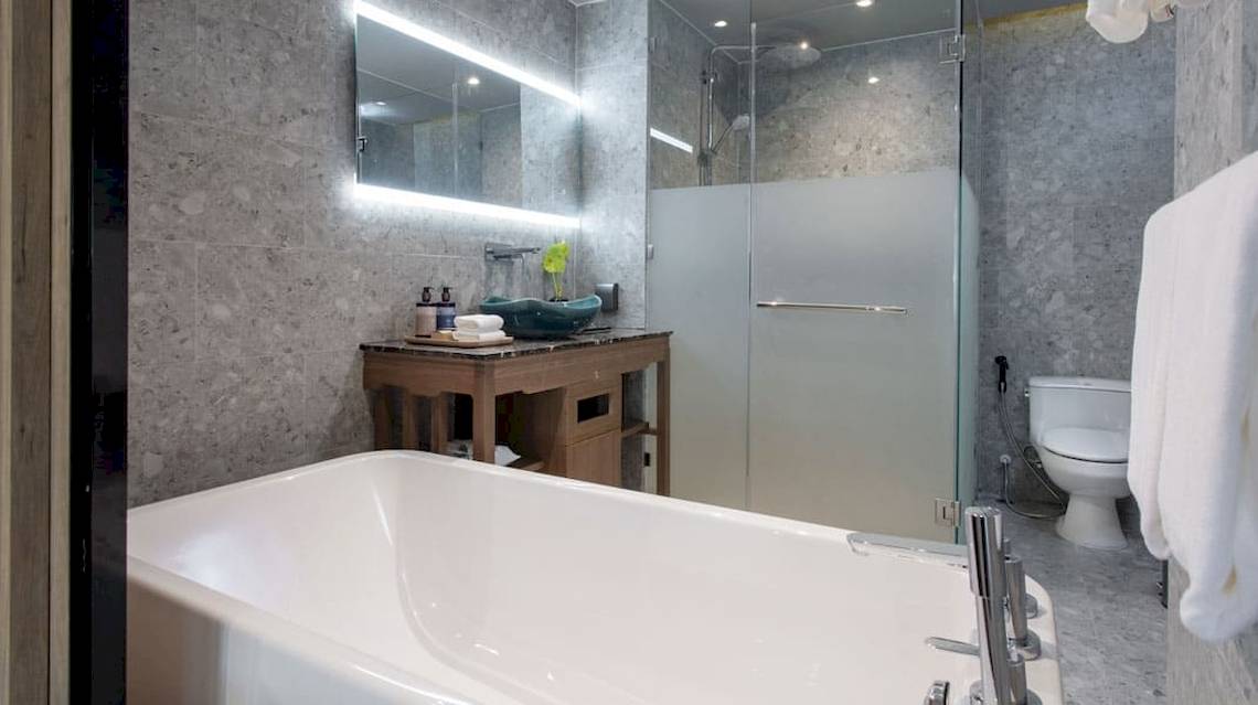 Ein Badezimmer im La Flora Khao Lak Hotel mit Badewanne, Waschtisch, Dusche und Toilette.