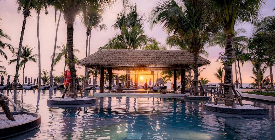 Außenbereich des La Flora Khao Lak Hotels mit Pool und Sonnenuntergang