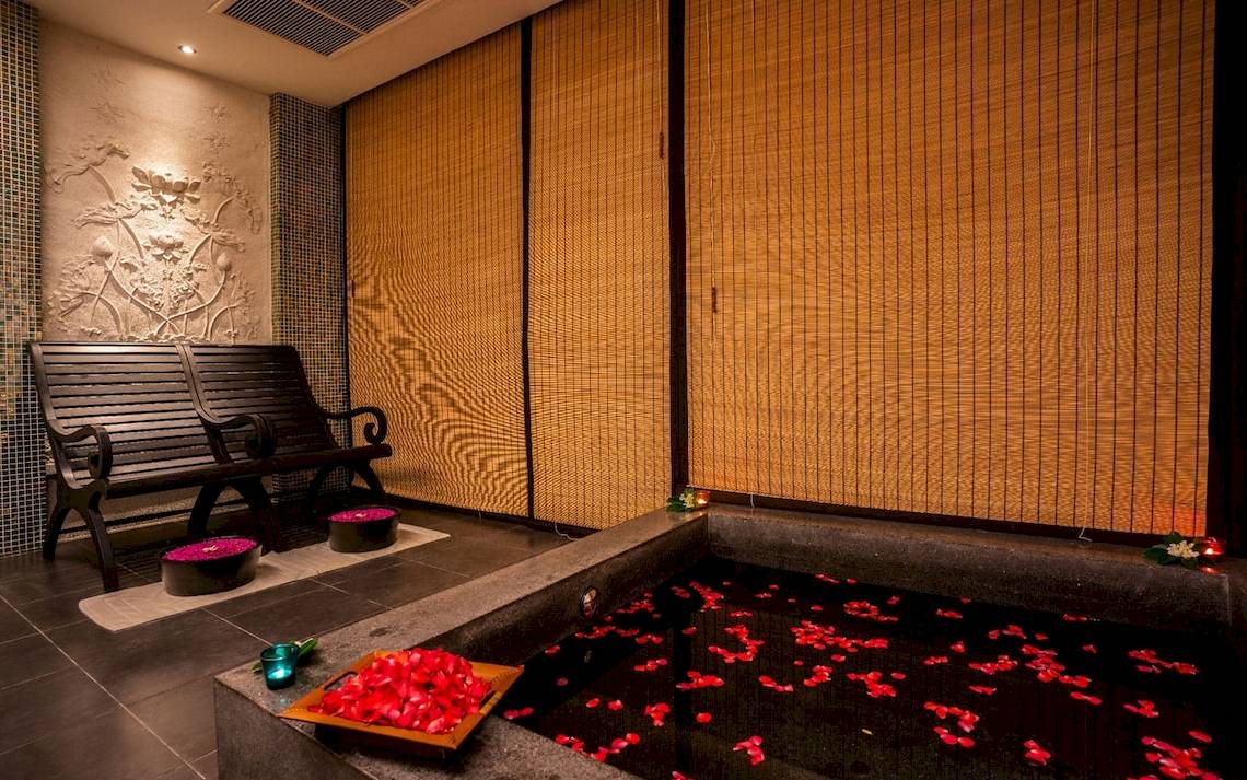 Wellnessbereich des La Flora Khao Lak Hotels mit einem großen Becken voller roter Rosenblätter.