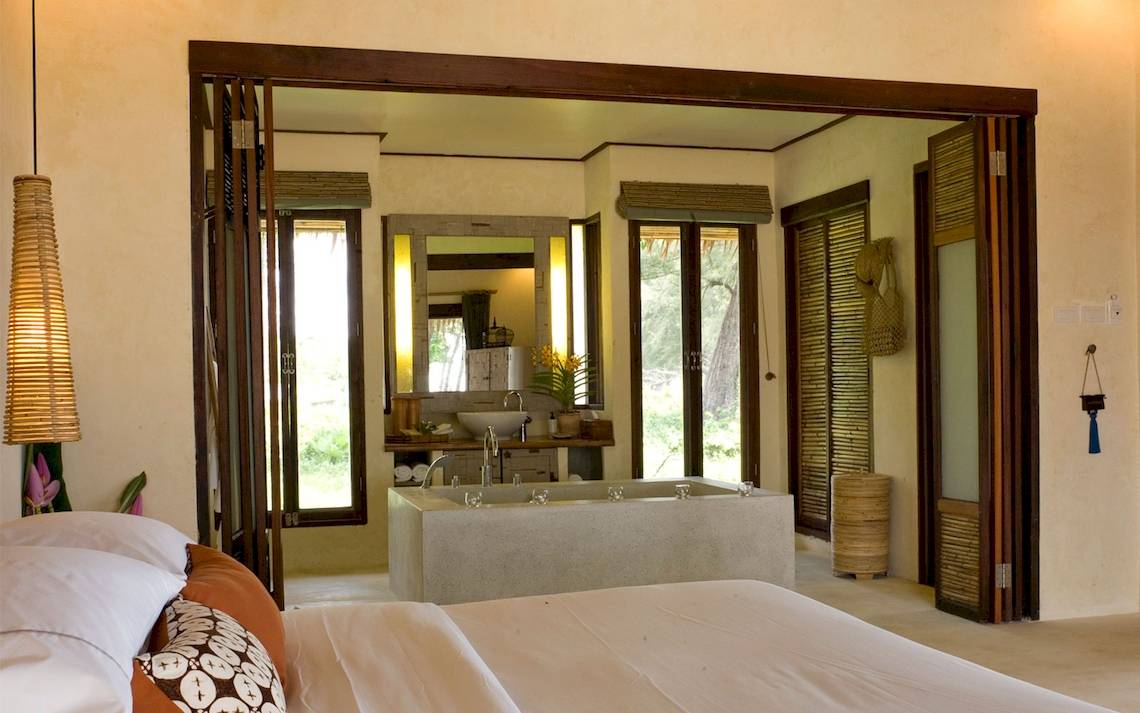 Schlafzimmer im Bangsak Village Hotel mit großem Bett und Badewanne.