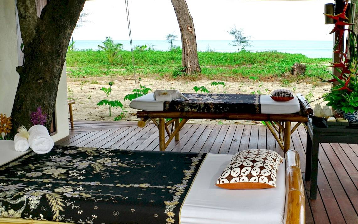 Massageliegen auf der Terrasse des Bangsak Village mit Blick auf das Meer.