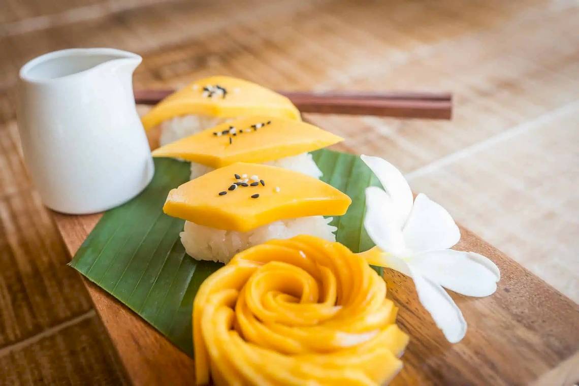 Essen auf Blatt serviert mit weißer Blume und weißem Krug
