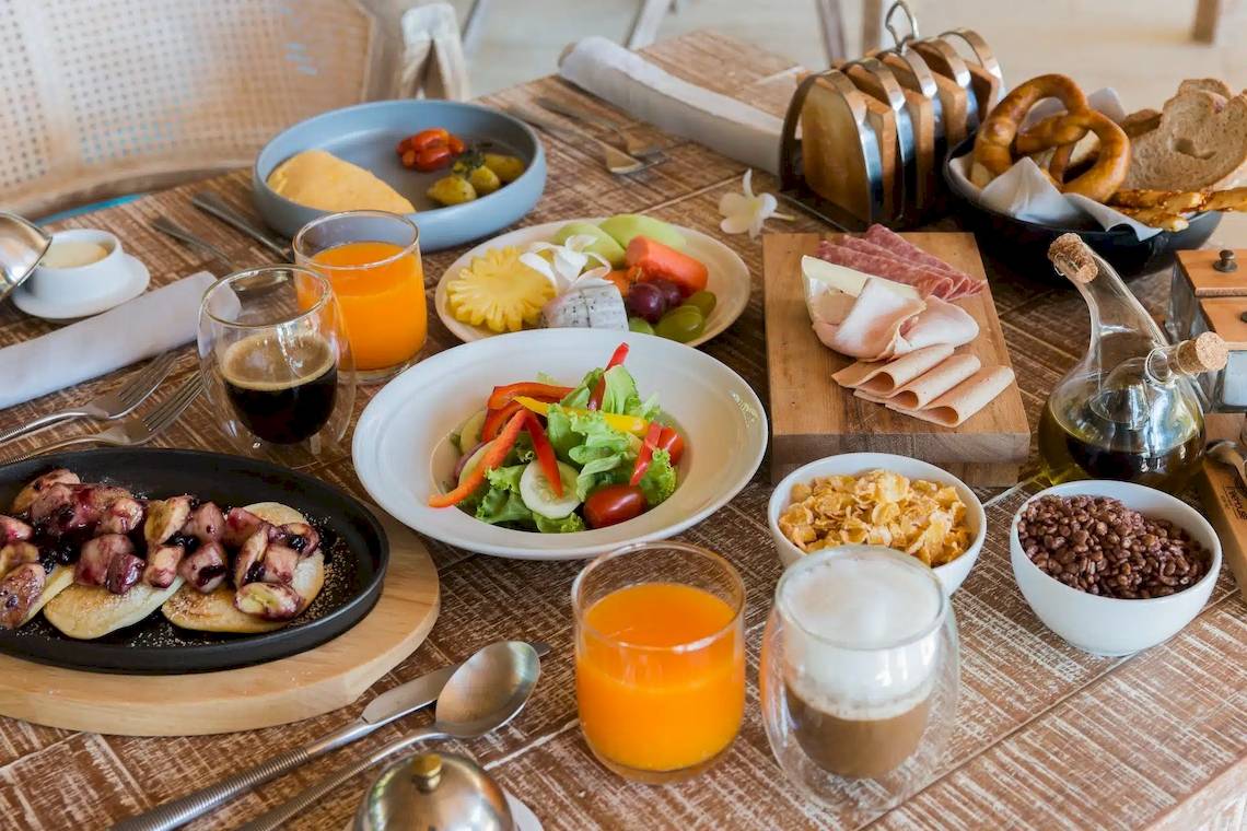 Frühstücksbuffet im TreeHouse Villas Koh Yao mit verschiedenen Gerichten und Getränken.