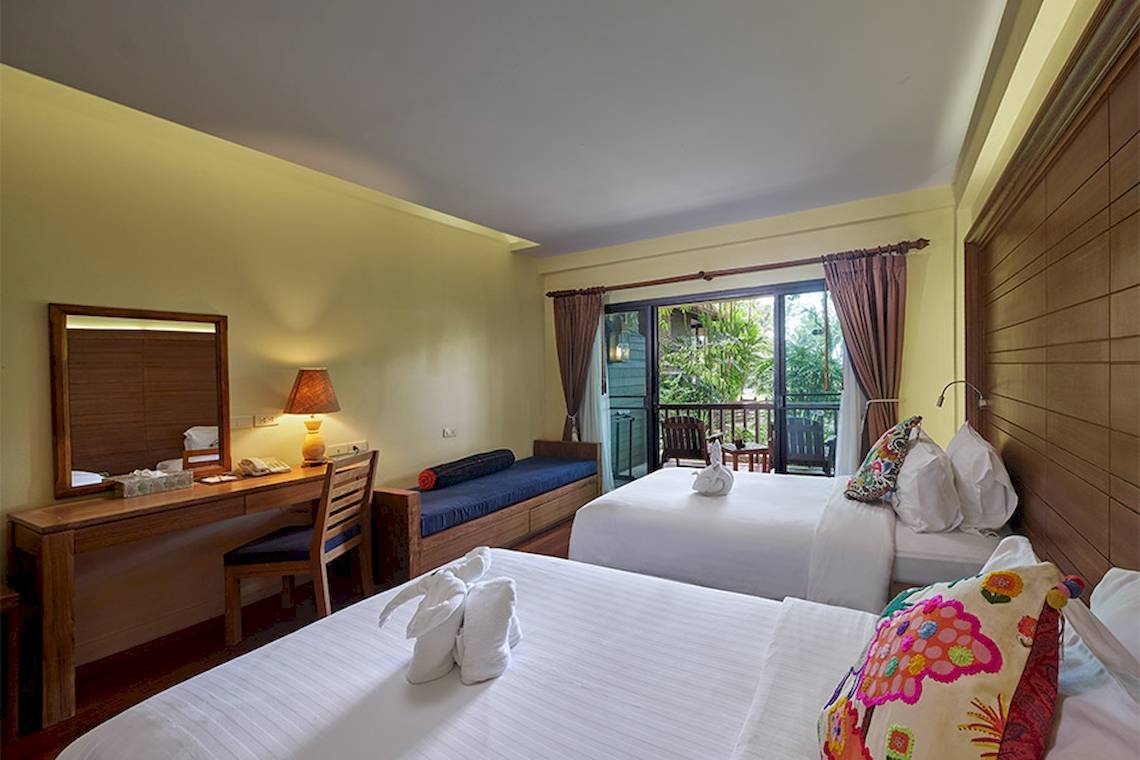 Zwei Hotelzimmer im Khaolak Paradise Resort mit Balkon, Betten und Schreibtisch.