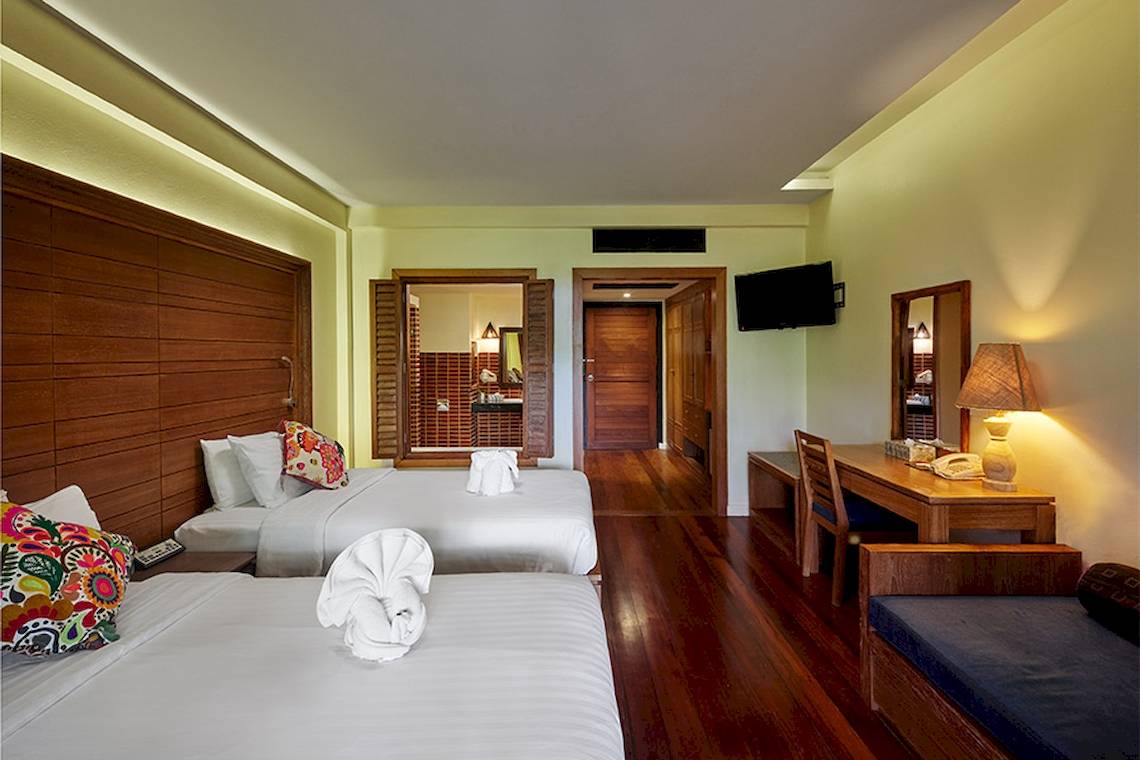 Dreibettzimmer im Khaolak Paradise Resort Hotel mit zwei Betten, Schreibtisch, Fernseher und Badezimmer