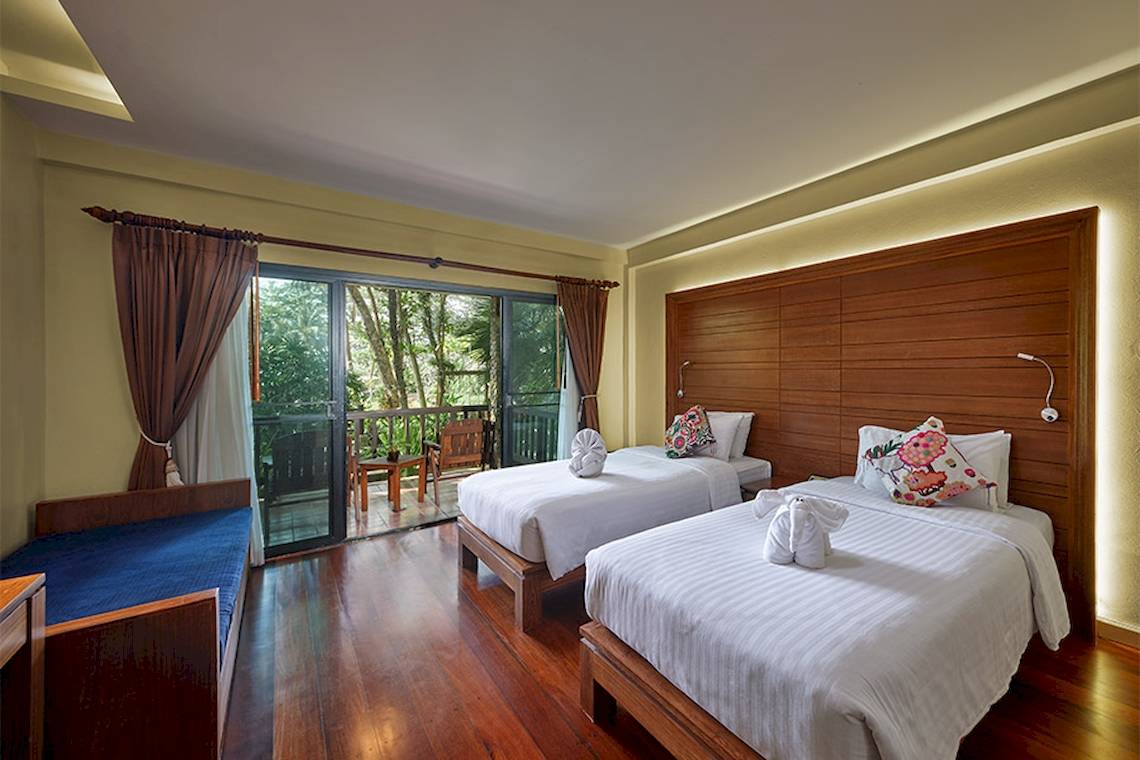 Zimmer im Khaolak Paradise Resort mit zwei Betten, Terrasse und Blick auf die Natur.