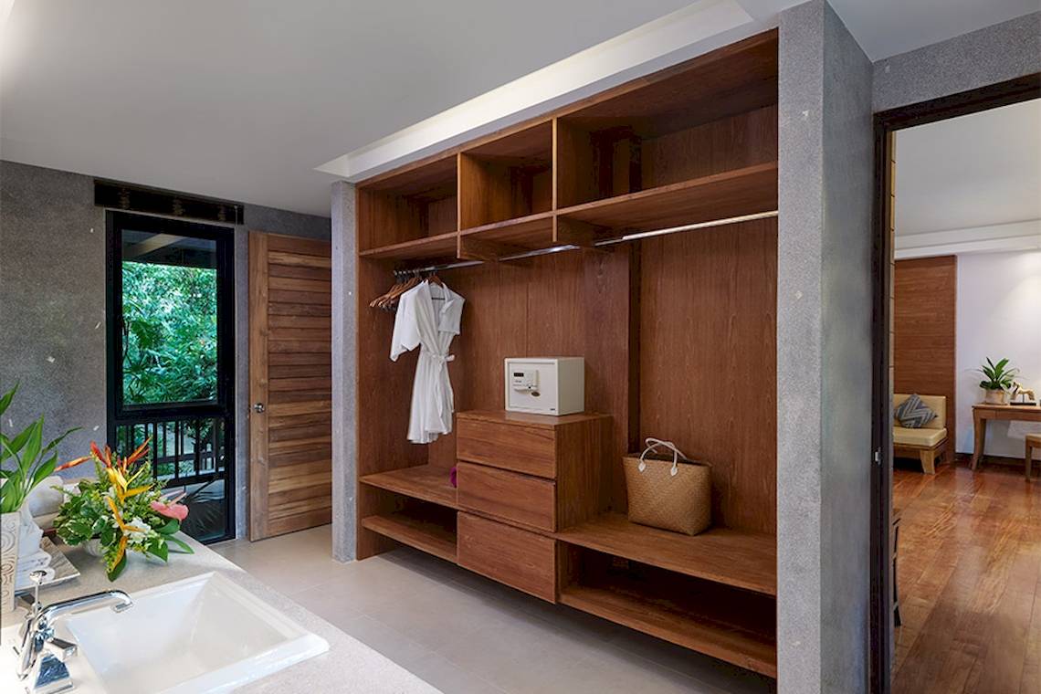 Kleiderschrank im Zimmer des Khaolak Paradise Resorts mit gepackten Kleidern, einem Safe und einem Korb