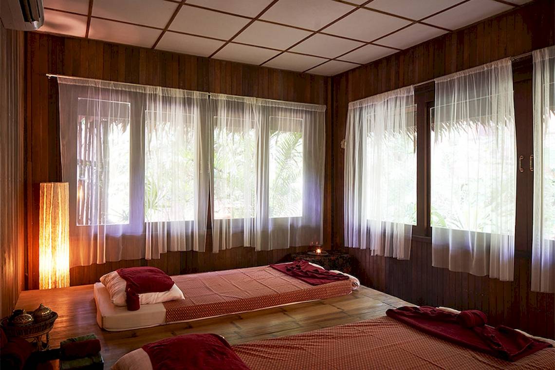 Massageraum im Khaolak Paradise Resort mit zwei Betten und Vorhängen.