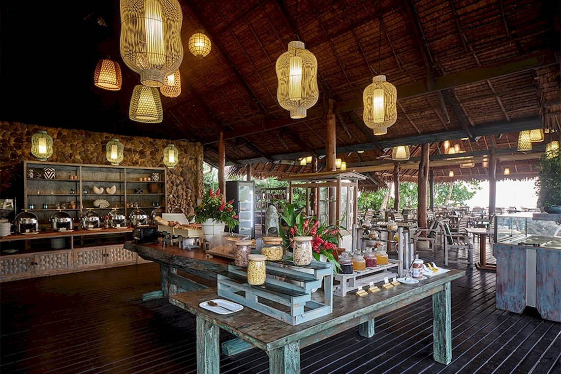 Innenansicht des Speisesaals im Khaolak Paradise Resort mit Buffet, Tischen und hängenden Lampen.