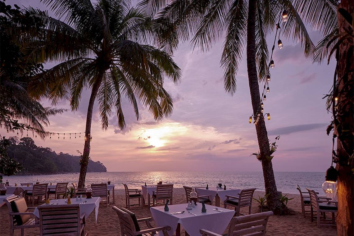 Bestuhlter Essbereich auf dem Strand des Khaolak Paradise Resorts bei Sonnenuntergang