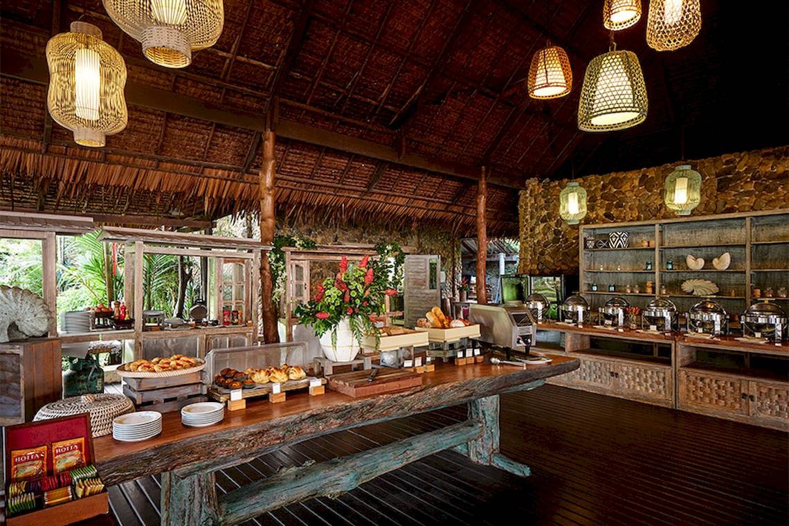 Frühstücksbuffet im Khaolak Paradise Resort mit Tisch, Blumen und verschiedenen Gerichten.