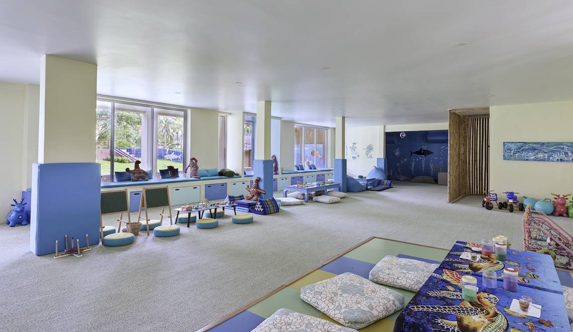 Kinderzimmer im Santiburi Koh Samui Hotel mit blauen Möbeln und Teppichen.