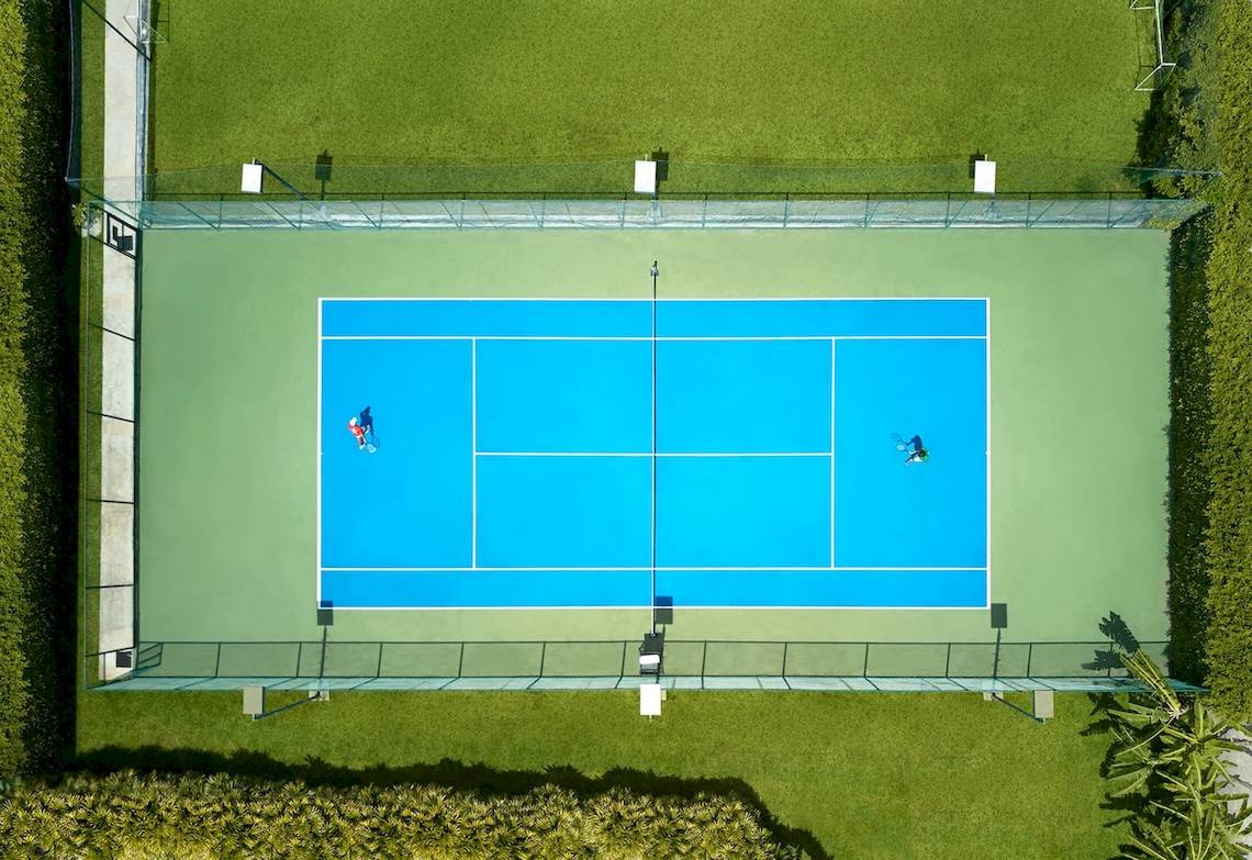 Luftaufnahme eines blauen Tennisplatzes mit zwei Spielern auf Santiburi Koh Samui