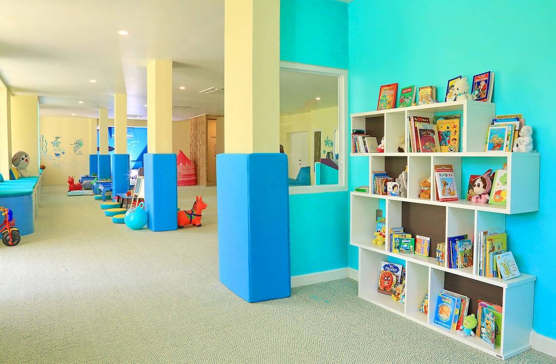 Kinderzimmer im Santiburi Koh Samui mit Büchern, Spielzeug und bunten Wänden.