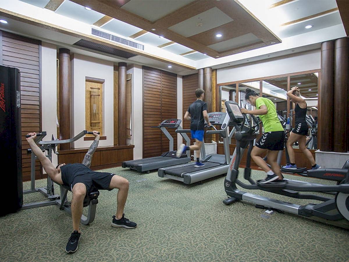Fitnessstudio im Khao Lak Merlin Resort mit Personen, die auf Laufbändern trainieren.