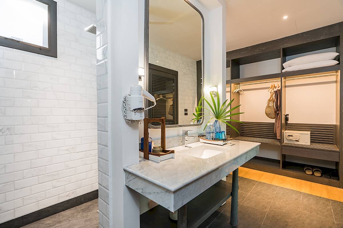 Badezimmer im Peace Resort mit einem Marmorwaschbecken, Spiegel und Garderobe.