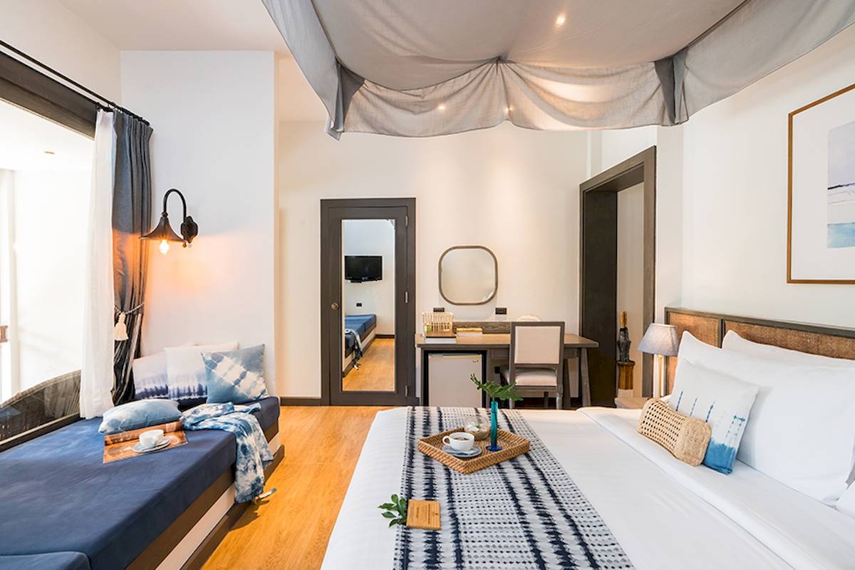 Schlafzimmer im Peace Resort mit zwei Betten, Schreibtisch, Spiegel und Dekoartikeln.