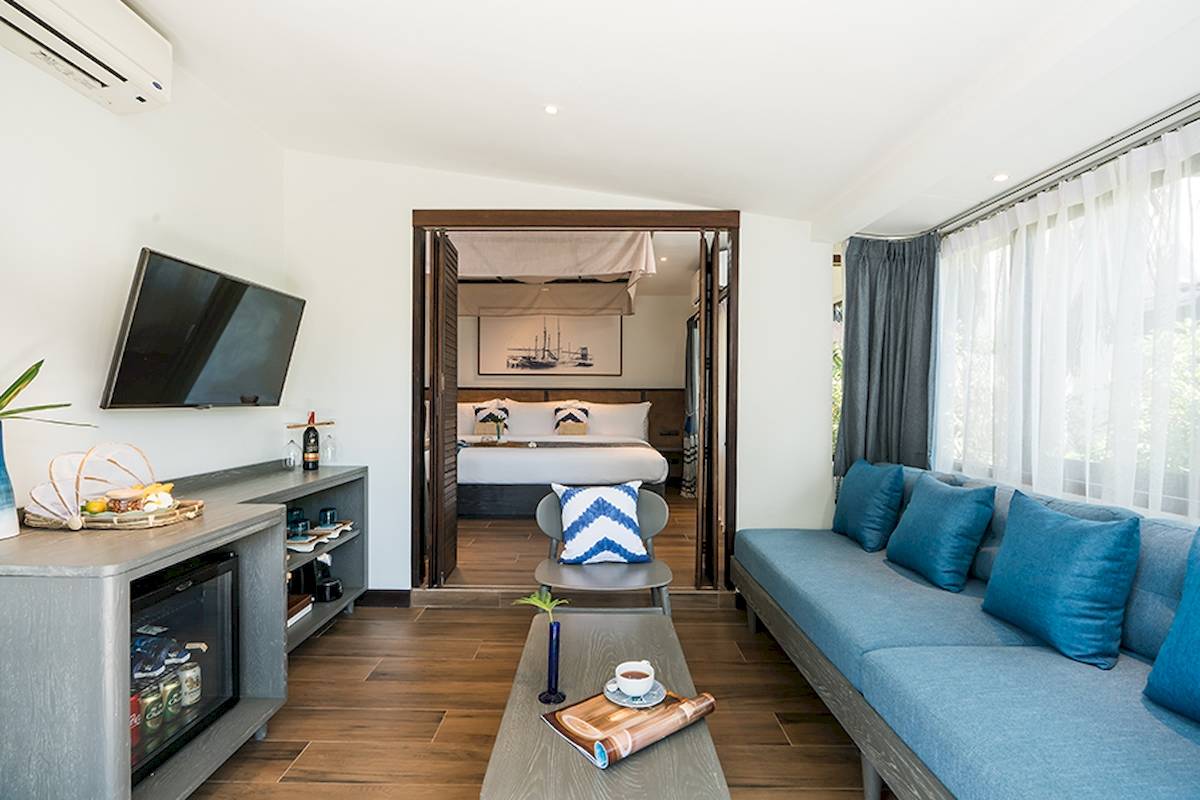Friedrich Villa: Wohnzimmer mit Sofa, Fernseher, Tisch und offenem Schlafzimmer