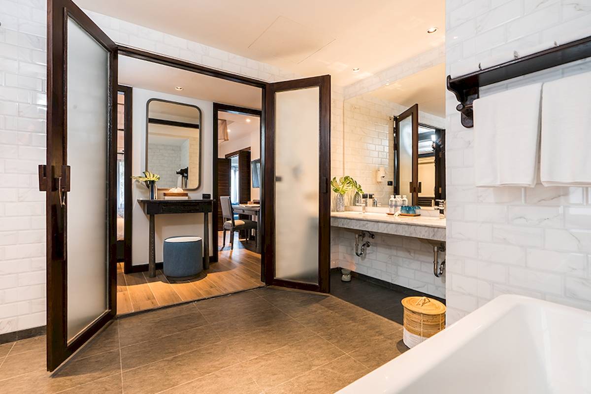 Innenansicht eines Badezimmers im Peace Resort mit Badewanne, Waschbecken und Toilettenartikeln.