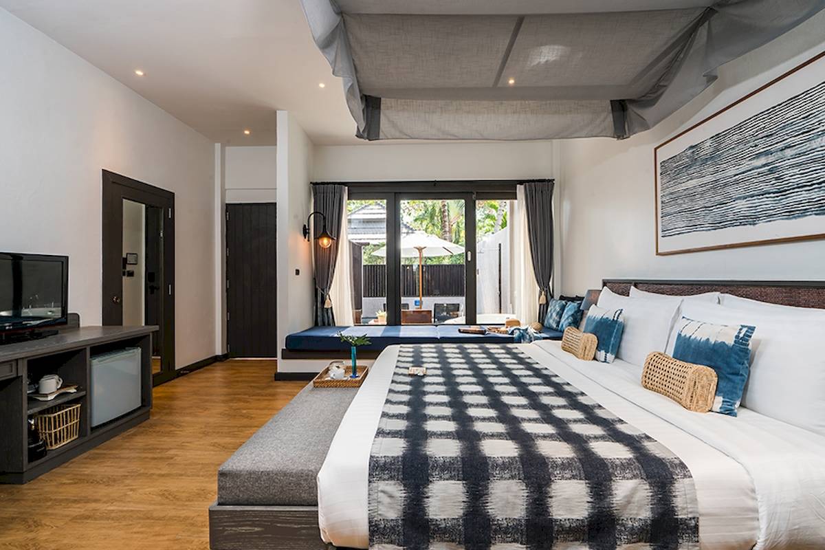 Schlafzimmer im Peace Resort mit Doppelbett, Fernseher, und großer Fensterfront.