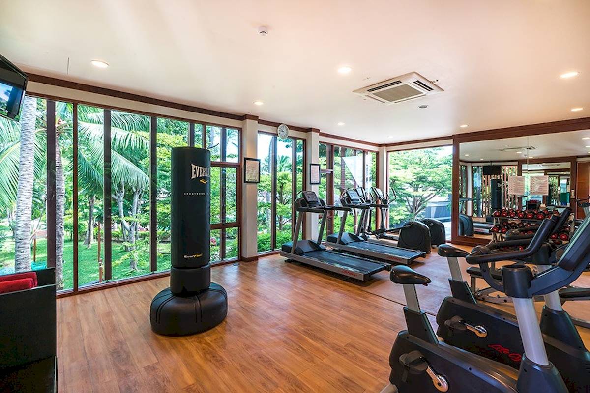 Fitnessstudio im Peace Resort mit Blick auf den Garten und großen Fenstern.