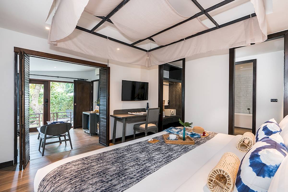 Innenansicht eines Zimmers im Peace Resort Hotel mit Bett, Schreibtisch und Fernseher.