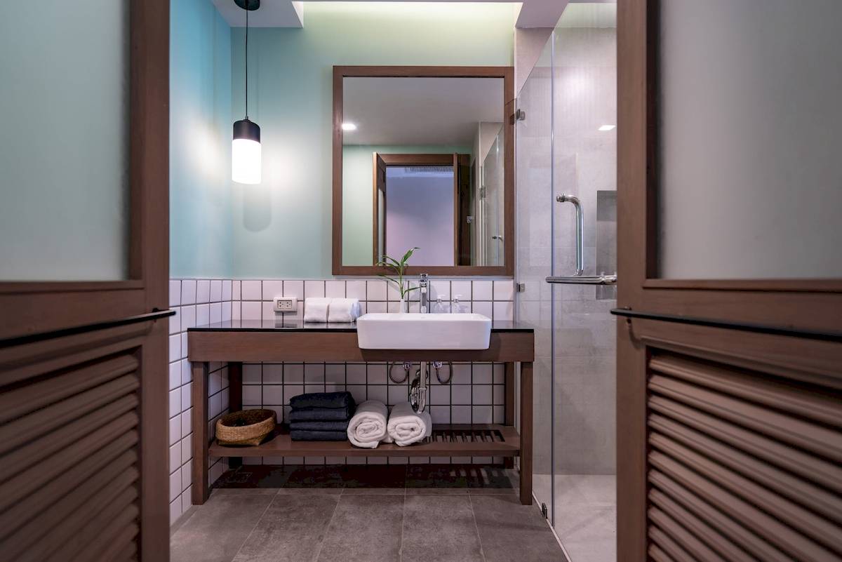 Badezimmer im Anana Ecological Resort Krabi mit weißem Waschbecken und grüner Pflanze.