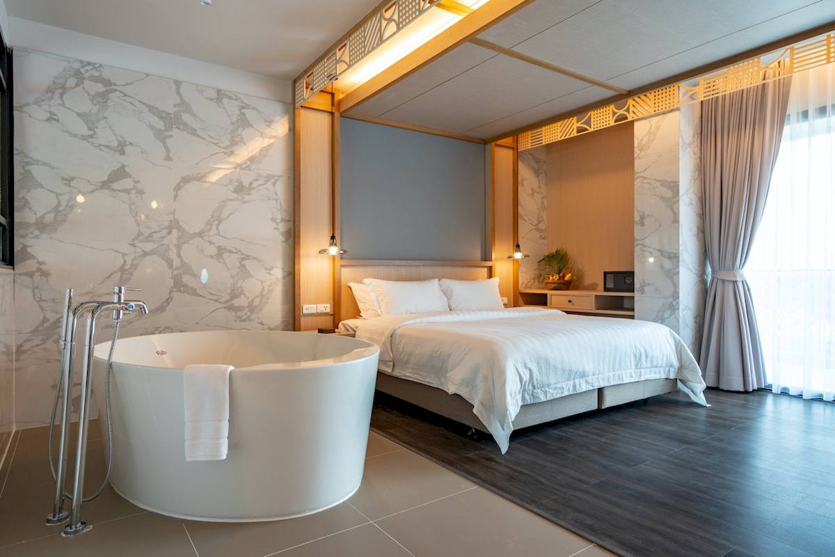 Schlafzimmer im Anana Ecological Resort Krabi mit Bett, Badewanne und Marmorwänden