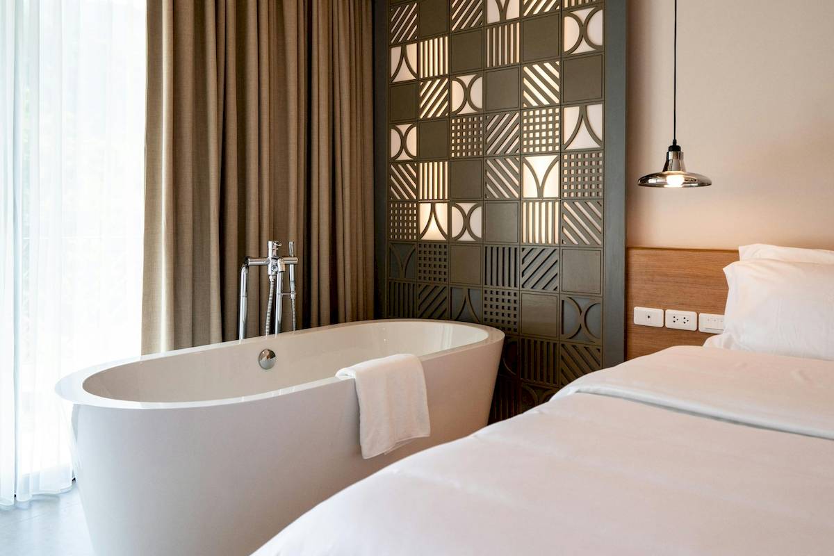 Schlafzimmer im Anana Ecological Resort Krabi mit Badewanne und moderner Wandgestaltung.