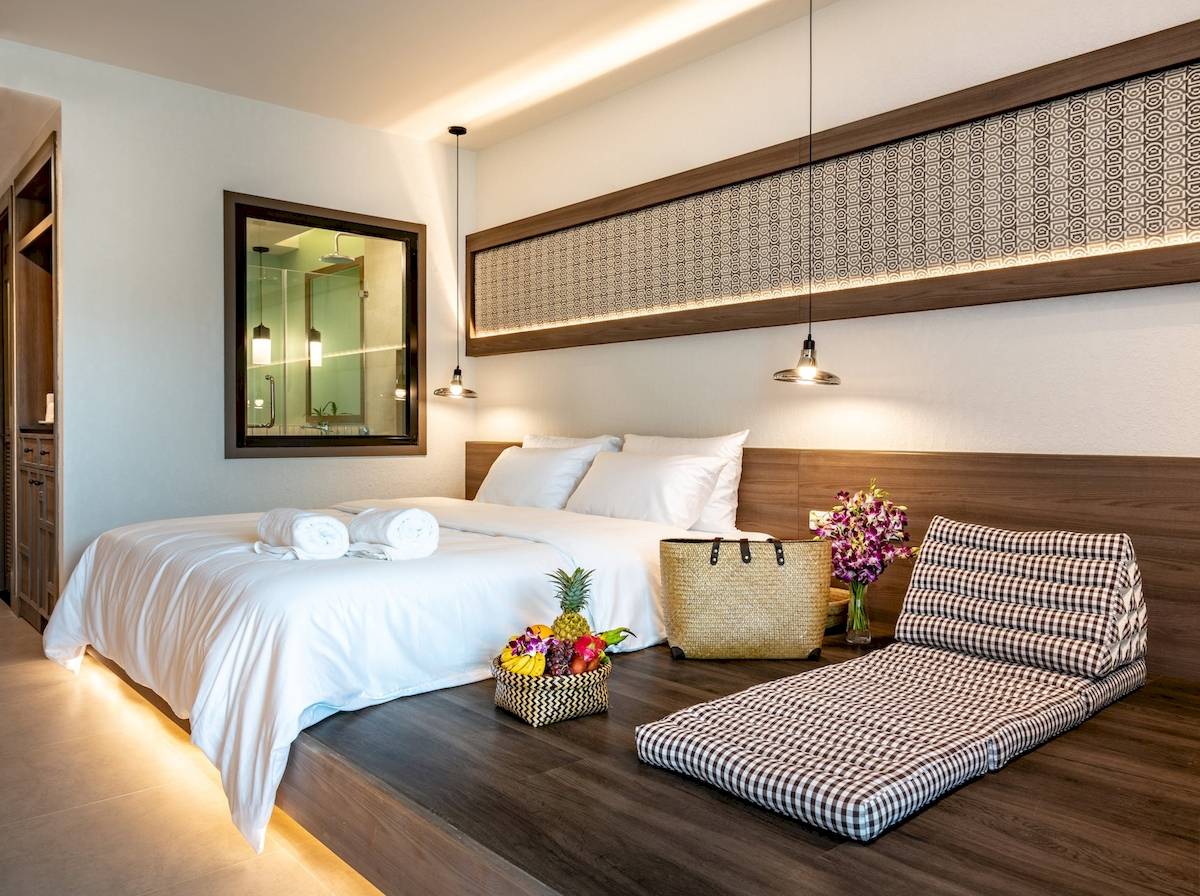 Innenansicht eines Schlafzimmers im Anana Ecological Resort Krabi mit Bett, Früchtekorb und Dekokissen.