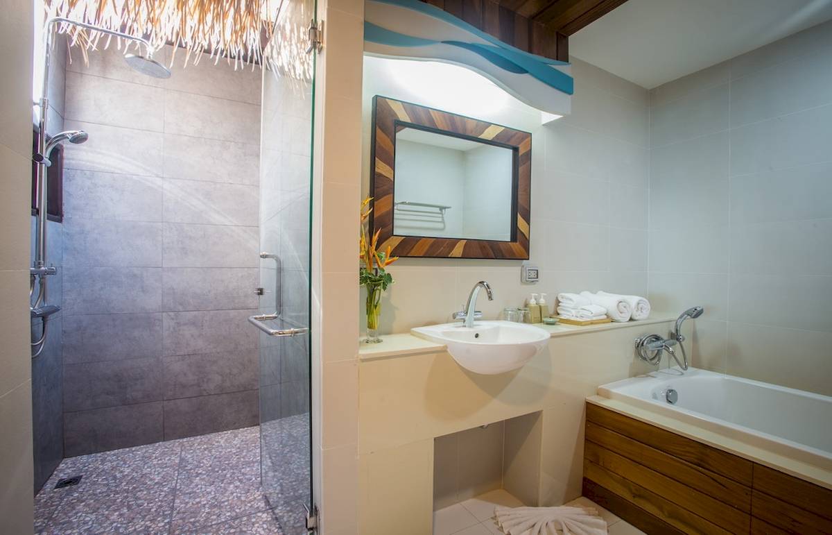 Badezimmer im Tup Kaek Sunset Beach Resort mit Dusche, Waschbecken und Badewanne.