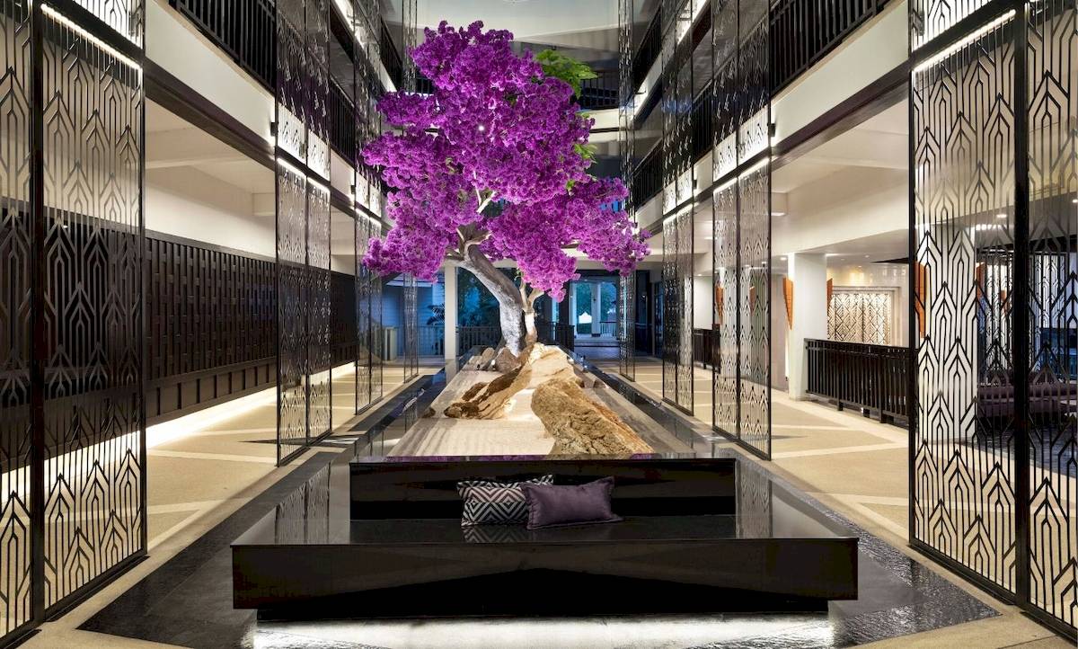 Innenbereich des Aonang Villa Resorts mit einem großen blühenden Baum.