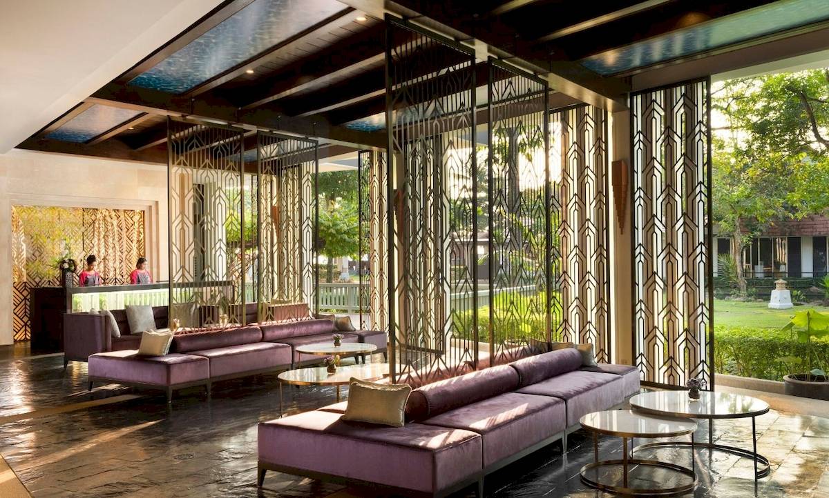 Empfangshalle des Aonang Villa Resorts mit violetten Sofas und modernen Metallschirmen.