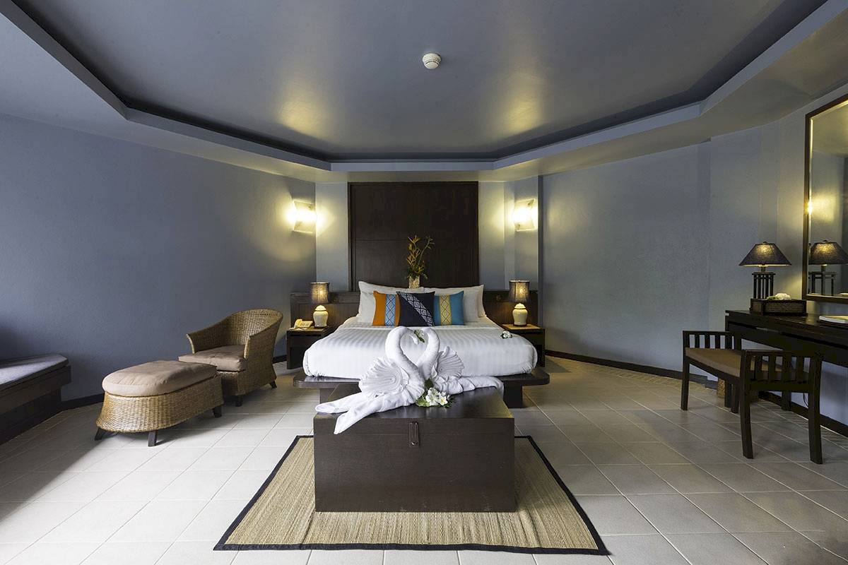 Ein modernes Schlafzimmer mit einem großen Bett, zwei weißen Schwanen und einem Nachttisch auf beiden Seiten.