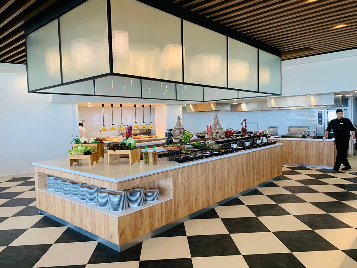 Buffetbereich im Creta Princess Aquapark & Spa mit verschiedenen Gerichten und einem Kellner in der Nähe.