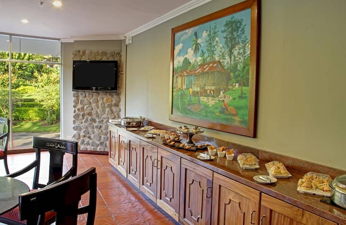 Speisesaal im DoubleTree by Hilton Hotel Cariari San Jose mit Buffet, Fernseher und Gemälde.