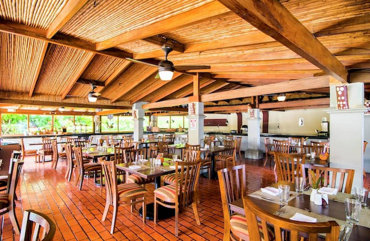 Innenansicht des Restaurants im DoubleTree by Hilton Hotel Cariari San Jose mit hölzernen Decken und Tischen.