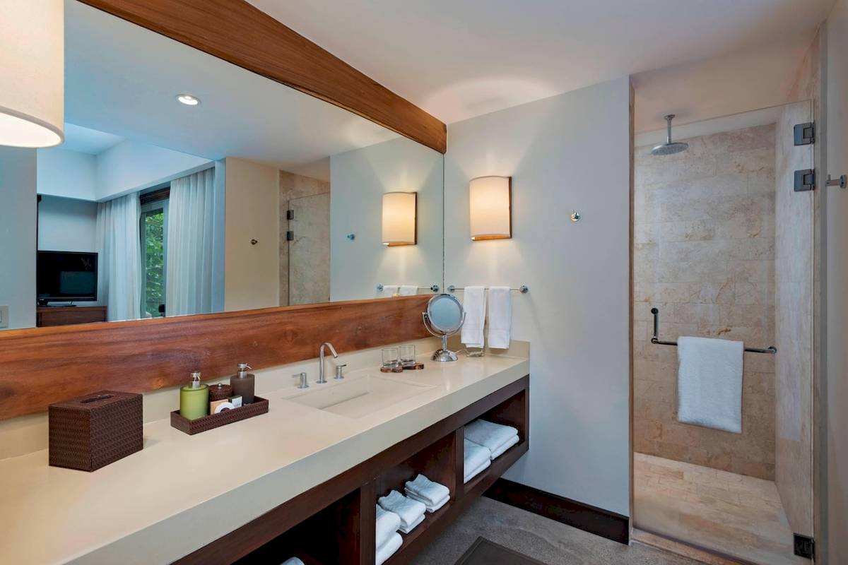 Hotelbadezimmer mit Spiegel und Dusche im El Mangroove, Autograph Collection