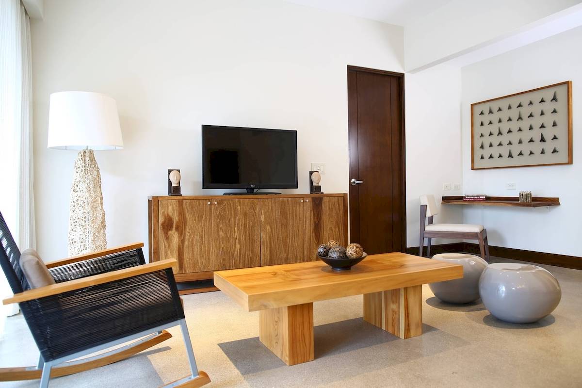 Wohnzimmer im El Mangroove, Autograph Collection mit Fernseher, Couchtisch und Sessel.