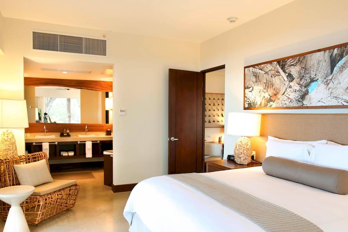 Hotelzimmer im El Mangroove, Autograph Collection mit Bett, Nachttisch und Badezimmer