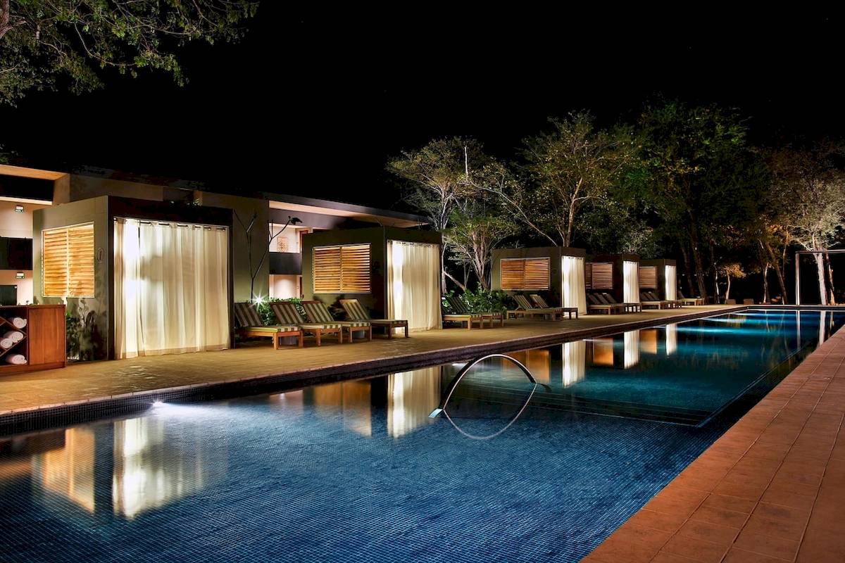 Nachtansicht des Pools und der Lounges im El Mangroove, Autograph Collection Hotel.